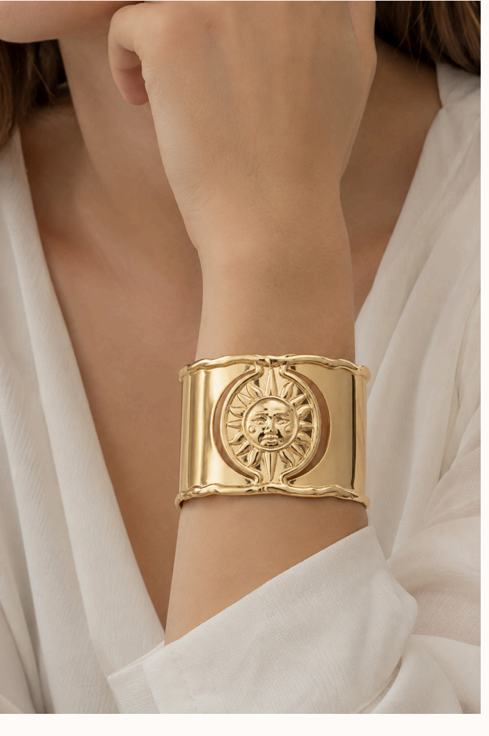 Golden Hour wide gold cuff with sunburst medallion, worn on the wrist