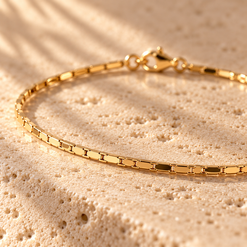 Thin Margin bracelet macro close-up: flat polished gold links and lobster clasp