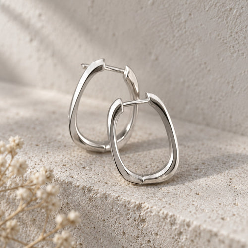 Square Deal squared hoop earrings in sterling silver on a travertine ledge