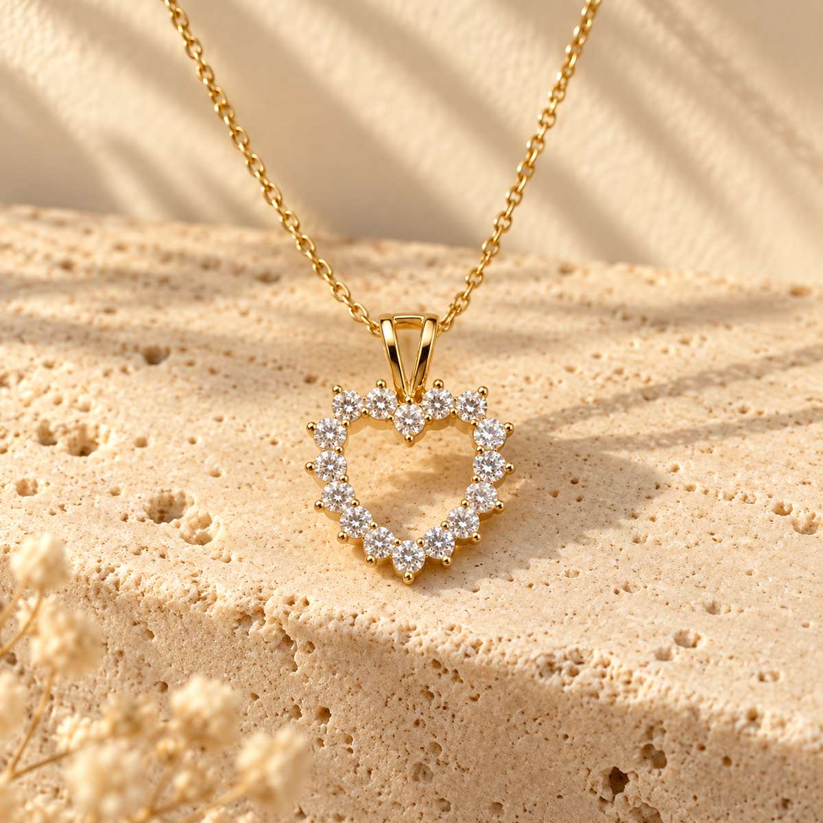 Open Offer Single Row gold open-heart pendant on a travertine ledge