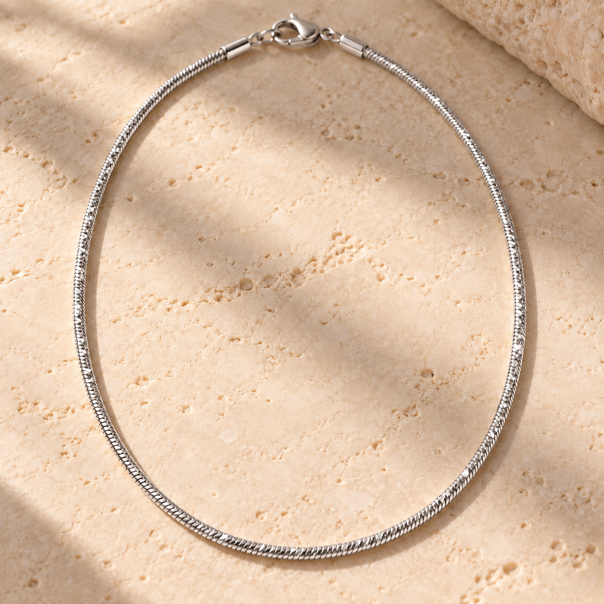 Bar None diamond-cut snake chain necklace in sterling silver on travertine