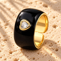 Collect the Shades Black macro close-up: glossy black enamel band with a bezel-set heart stone