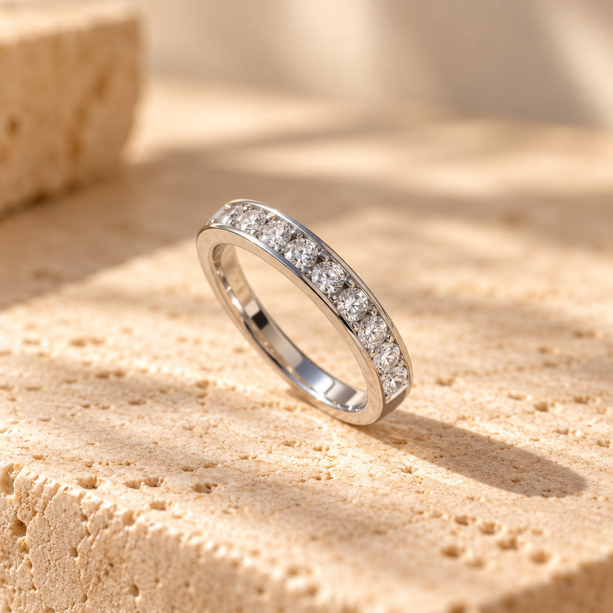 Straight Talk sterling silver band standing on a travertine ledge