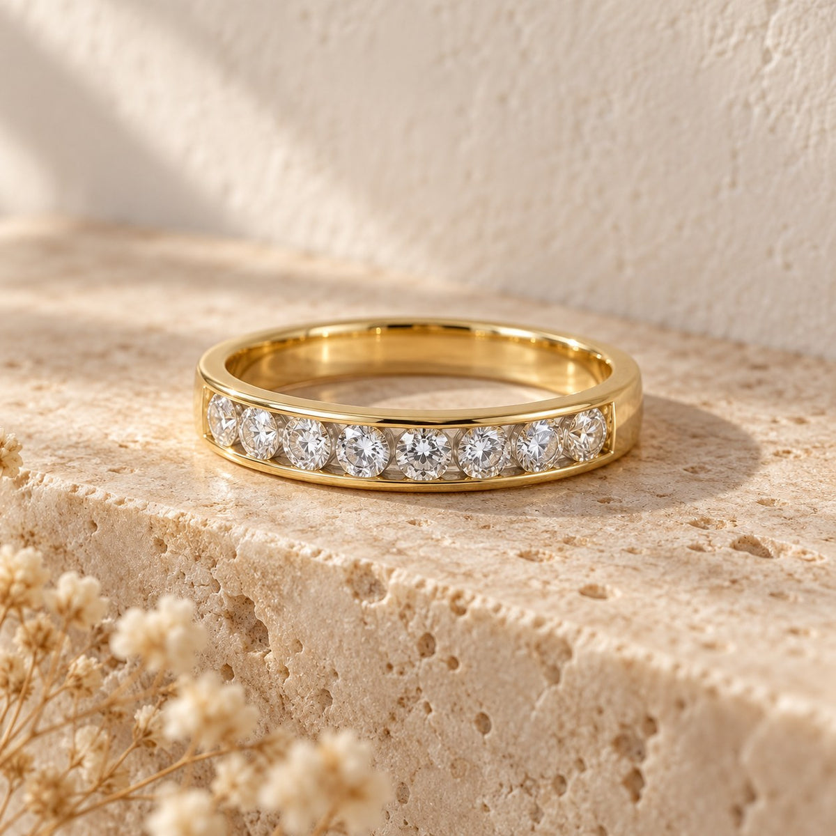 Straight Talk channel-set band in gold on a travertine ledge