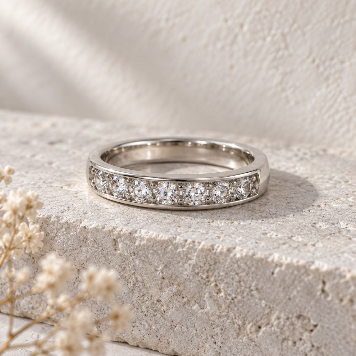 Straight Talk channel-set sterling silver band ring on a travertine ledge