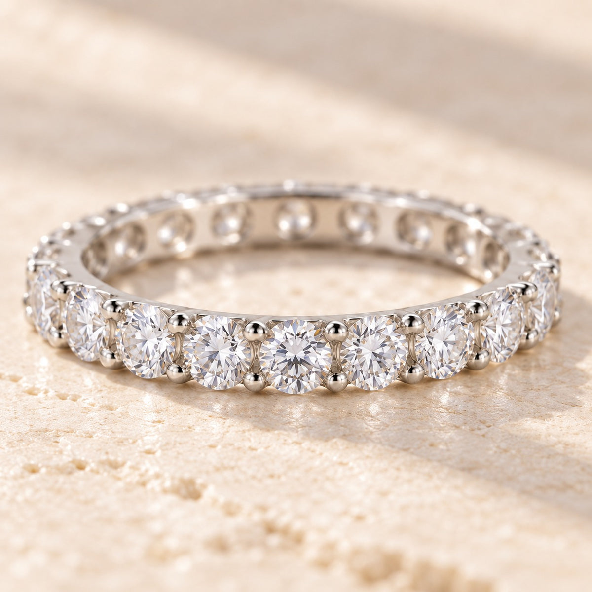 Raise the Stakes eternity ring close-up showing the shared-prong round stones all the way around the band