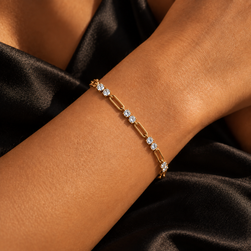 Chain Reaction bracelet worn on wrist against black satin