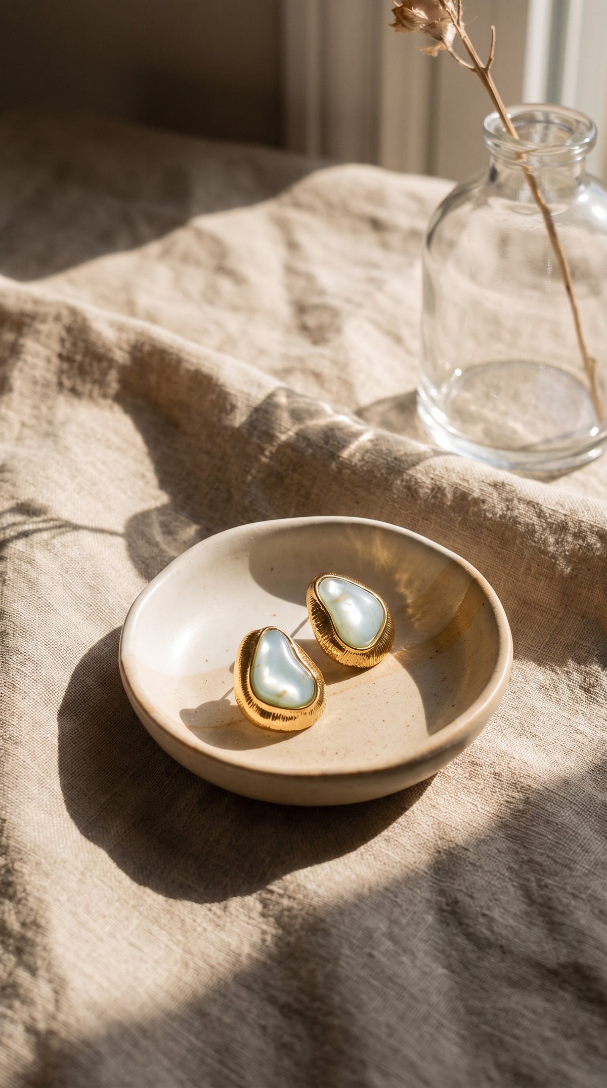 Organic Glow blue earrings styled in a ceramic dish on linen