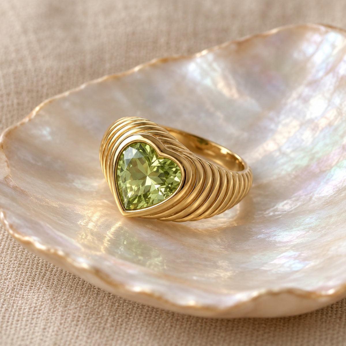 Sealed With a Heart ribbed gold ring with Apple Green heart stone on a shell dish (BU-RG-013-G)
